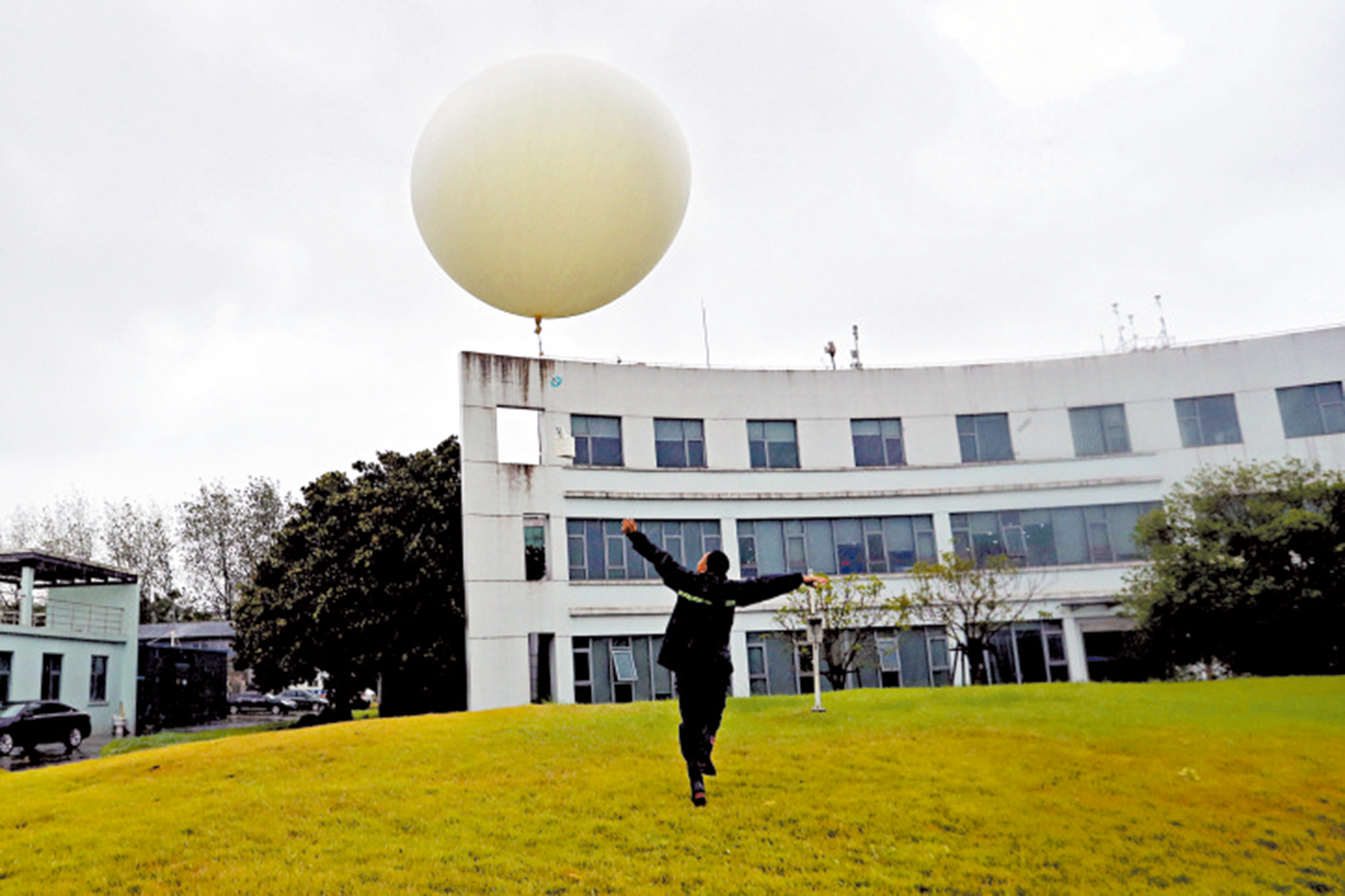 　　圖：上海市寶山區氣象局的氣象專家釋放帶有探空儀器的「探空氣球」。\中新社