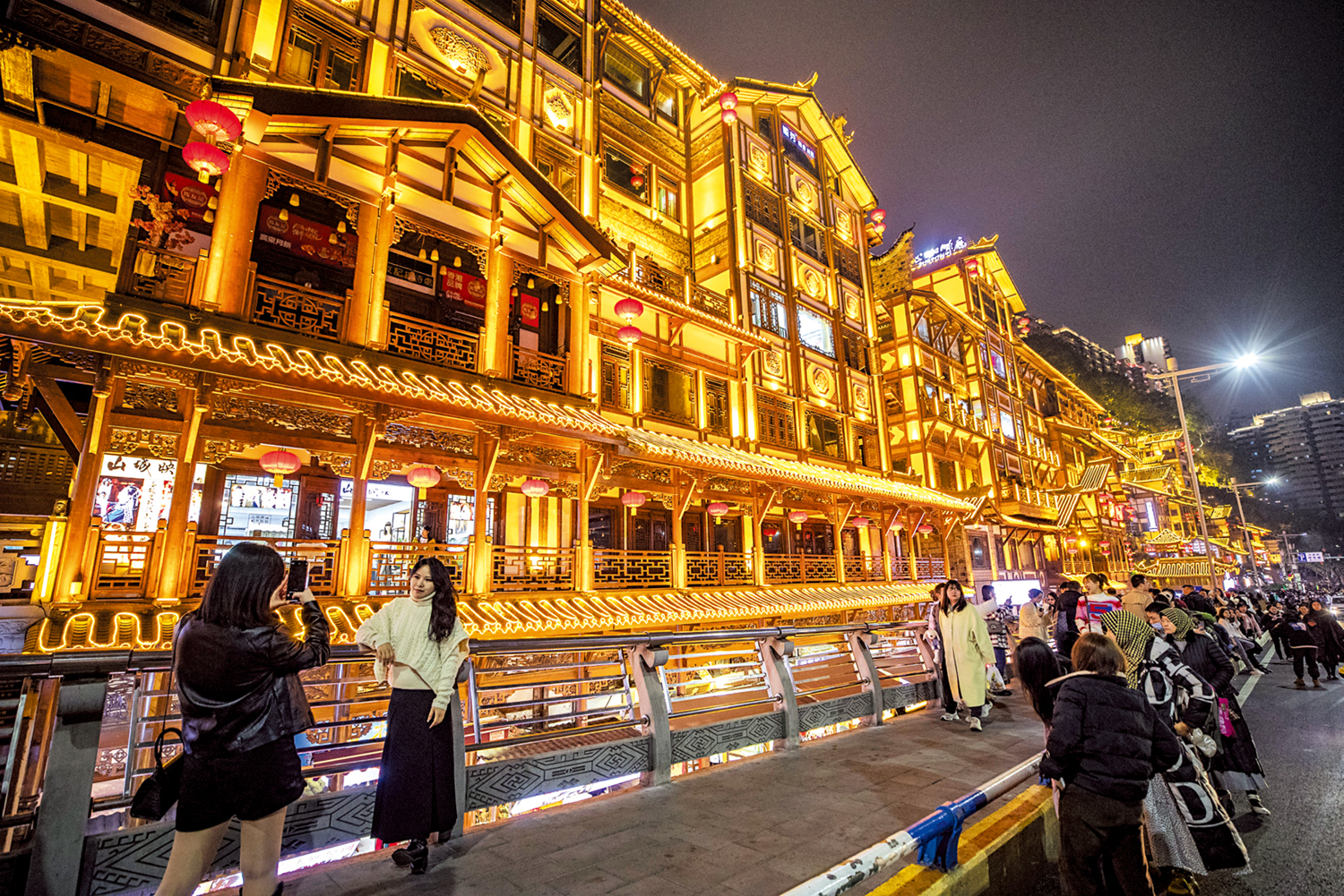 　　圖：2月10日晚，遊客在重慶市洪崖洞街區享受夜景、遊覽拍照。\新華社