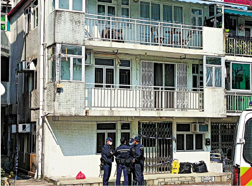 　　圖：警方昨日繼續圍封案發村屋進行調查，門外擺放兩個大膠袋，有軍裝警員駐守。\大公報古倬勳攝