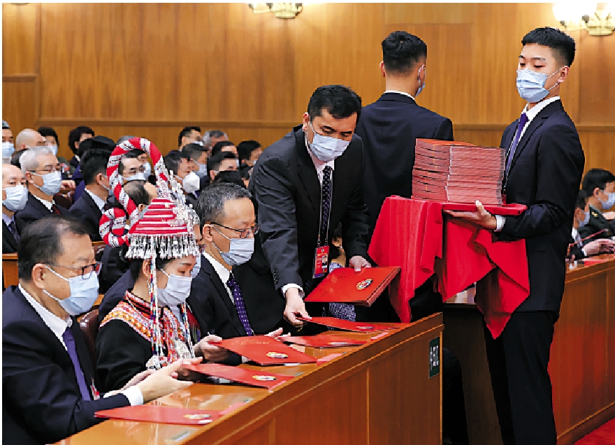 　　圖：全國政協十四屆一次會議10日在北京人民大會堂舉行第三次全體會議。這是工作人員發放選票。\新華社