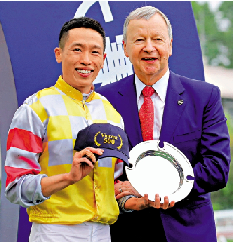 　　圖：何澤堯（左）從馬會行政總裁應家柏手上接過特製的Cap帽及銀碟。