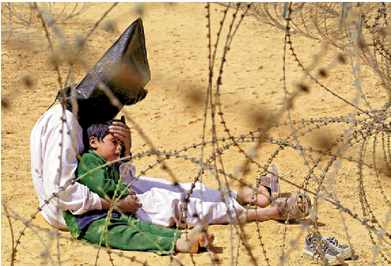 　　圖：一名被美軍關押的伊拉克囚犯安慰自己年僅4歲的兒子。\資料圖片