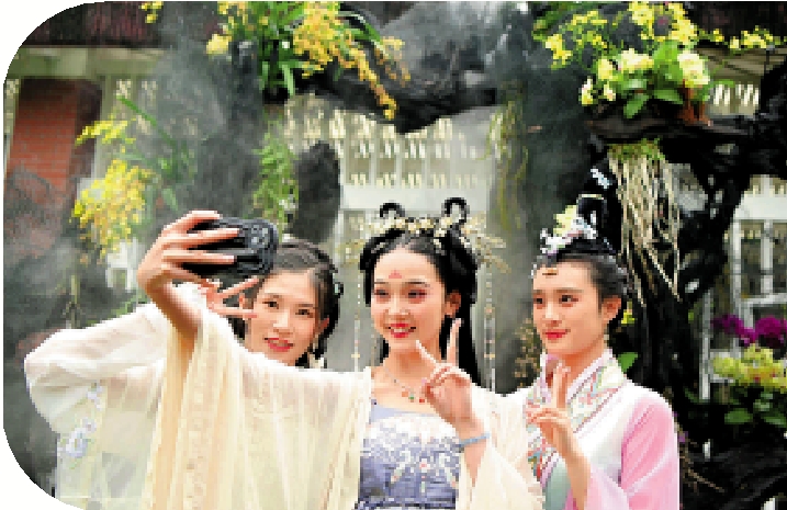 　　圖：4月9日，廣州漢服愛好者與蘭花藝術裝置合影。