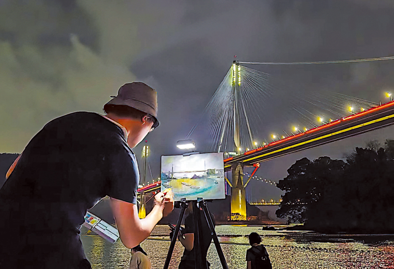 　　圖：有畫師在寫生，畫中有橋，有船，有藍眼淚，極富美感。