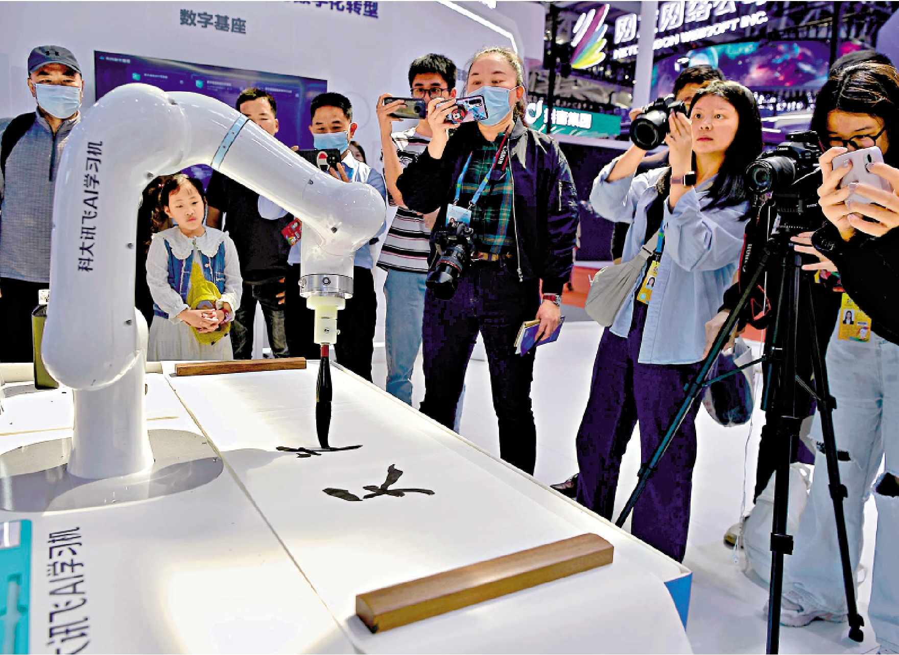 　　圖：4月27日，在福州舉行的第六屆數字中國建設成果展覽會上，一台AI書法機器人握着毛筆寫字。/中新社