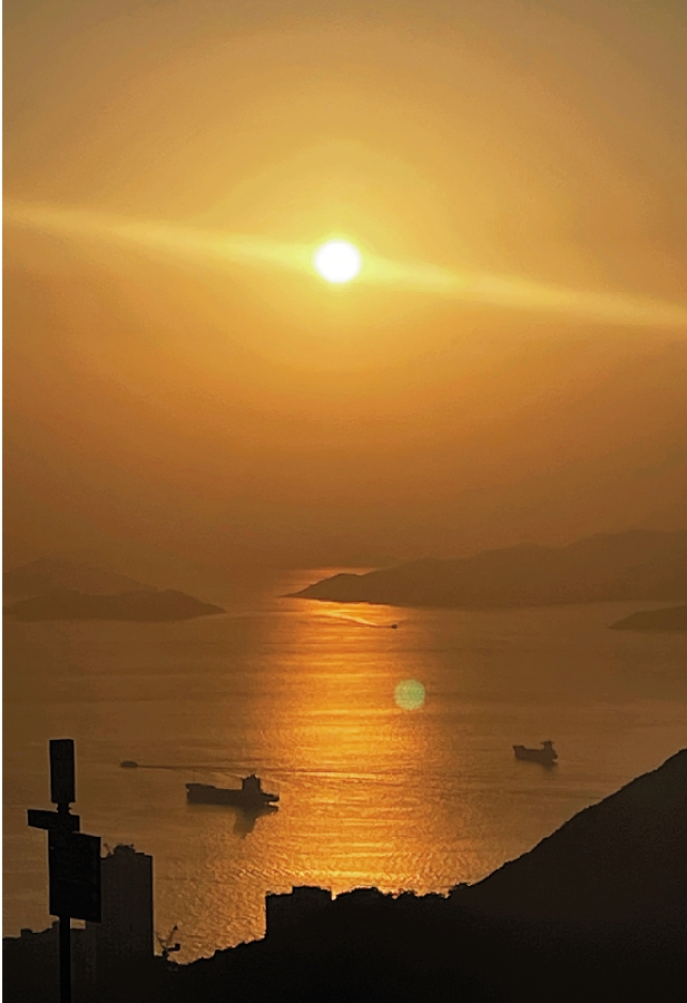 　　圖：在西高山山頂飽覽日落時分的維港景致。\大公報記者劉旅程攝
