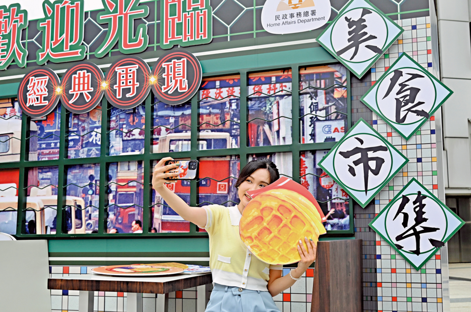 　　圖：5月6日，遊客與「開心香港」美食市集的「港式茶餐廳」展板自拍。\中新社