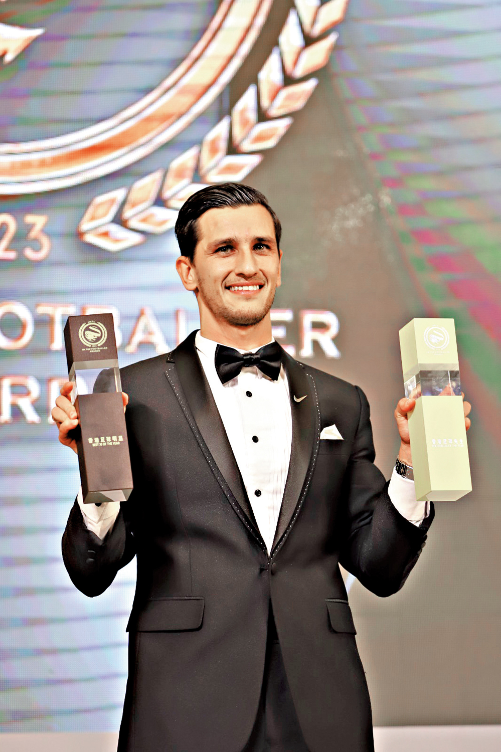 　　圖：明加索夫展示最佳十一人及香港足球先生獎座。