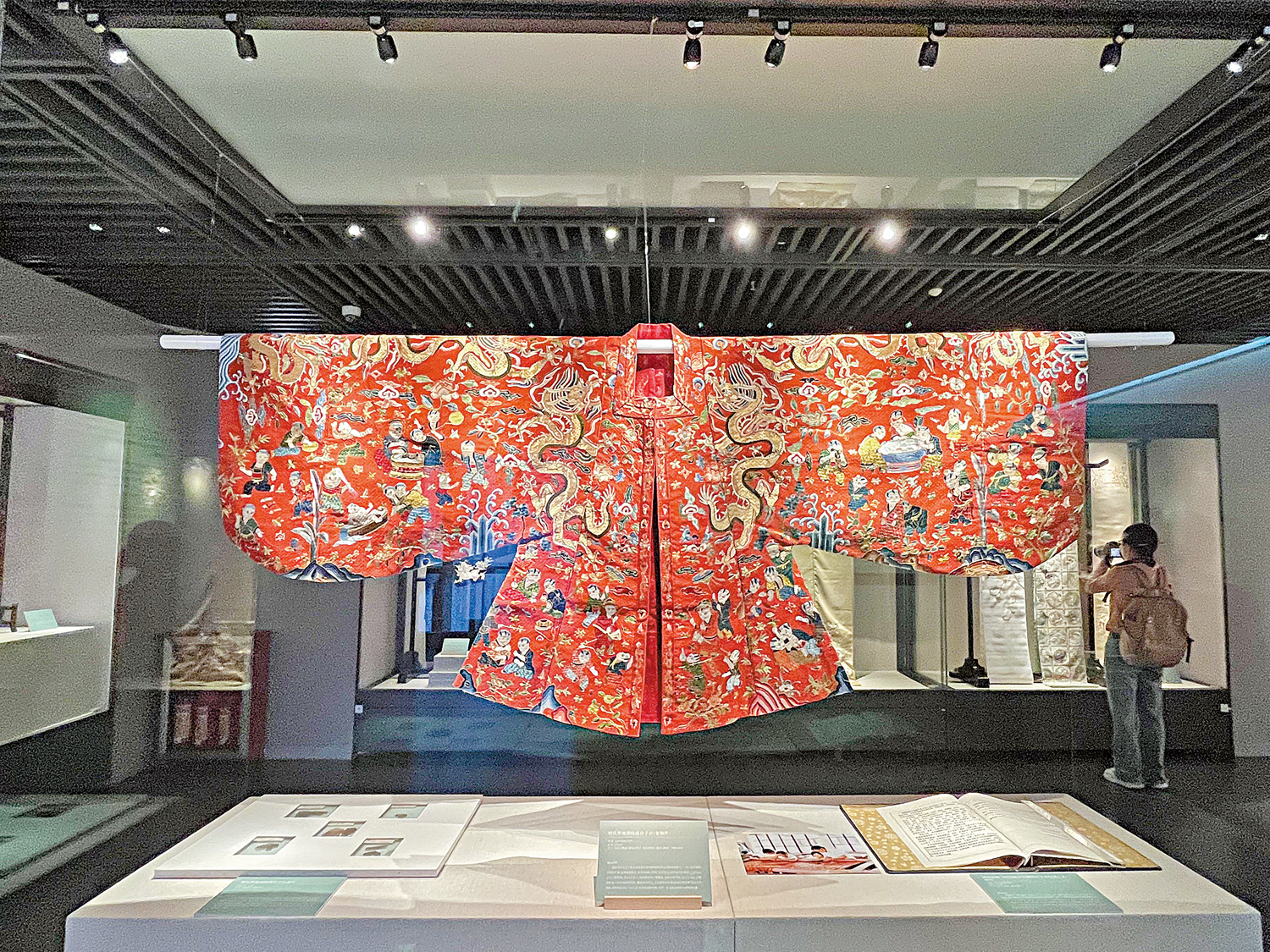 圖:深圳博物館展出蘇繡藝術文獻展,富麗堂皇的明代落地灑線繡百子衣複製件成為一大亮點。