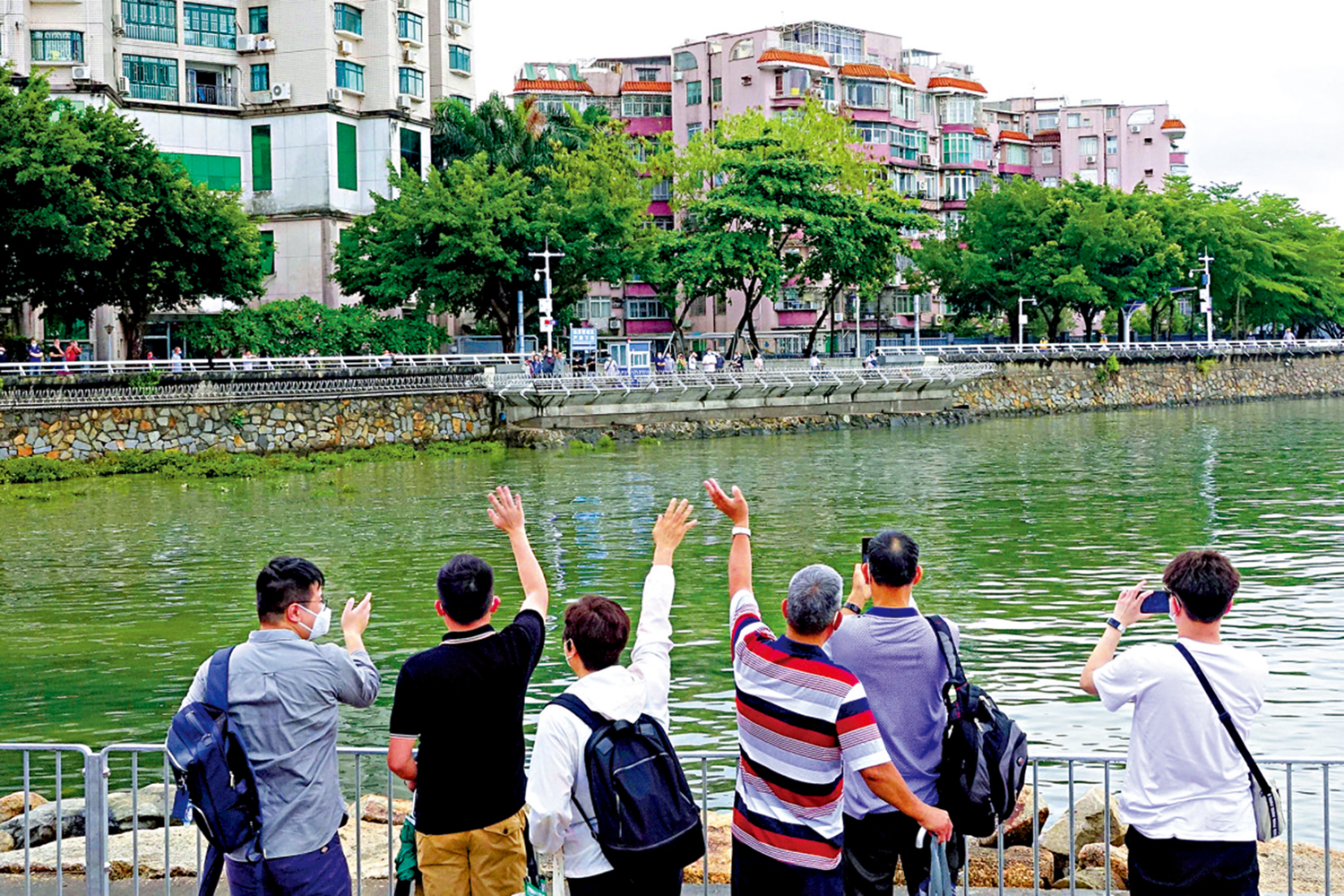 　　圖：遊客在沙頭角與對面的深圳市民「打招呼」，兩地市民盼望中英街可以盡早開放。