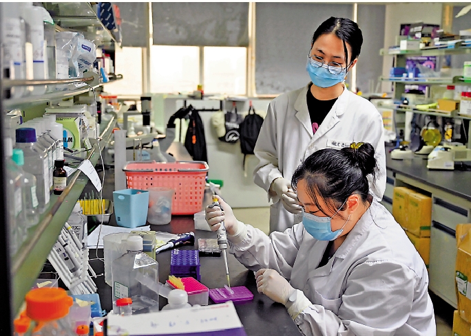 　　圖：吳淑寧（前）和師妹在暨南大學的實驗室做實驗。\中新社