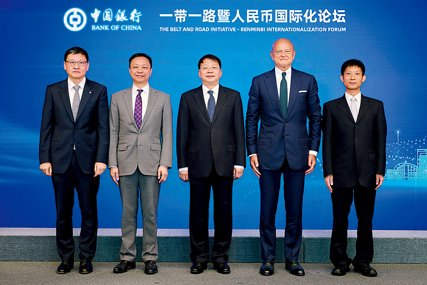 　　圖：中聯辦副主任尹宗華（中）、匈牙利央行副行長帕泰·米哈伊（右二）、香港金管局副總裁陳維民（左二）、中聯辦經濟部副部長譚亞波（右一）及中銀香港副董事長兼總裁孫煜（左一）昨日出席論壇時合影。