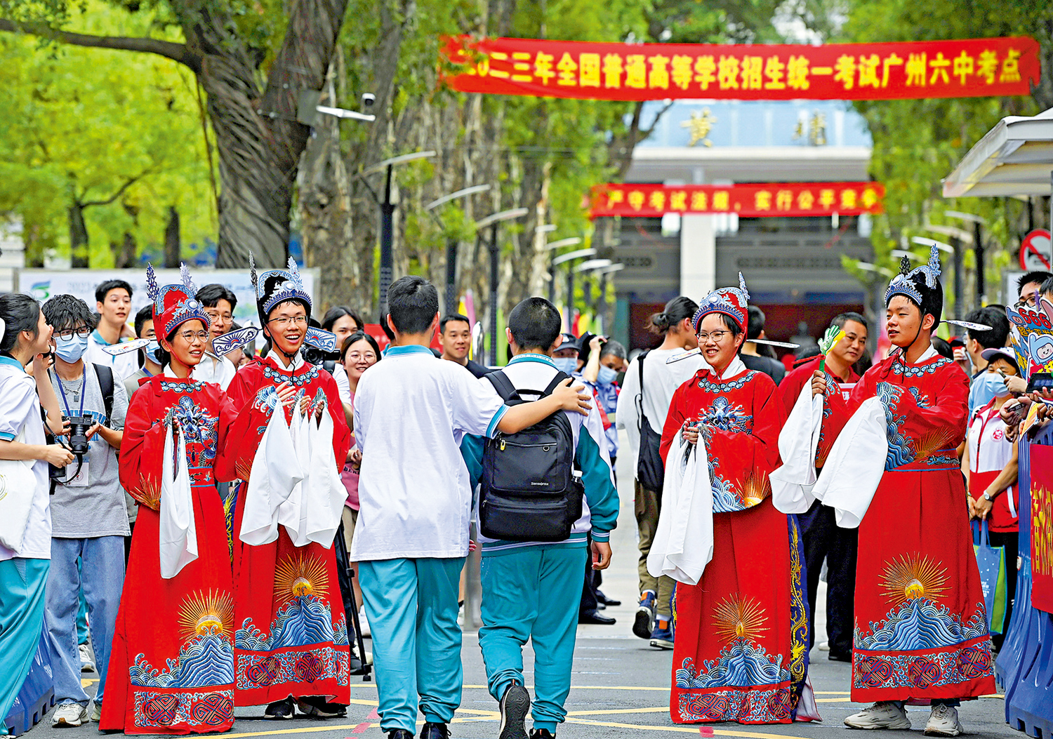 　　圖：6月7日，高考考生走進廣州市第六中學考點，來自該校的學生穿着傳統服飾為考生加油。\中通社