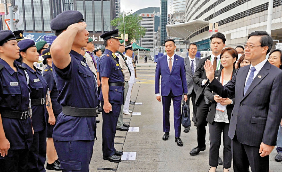 　　圖：行政長官李家超向觀禮的青少年制服團體問好。