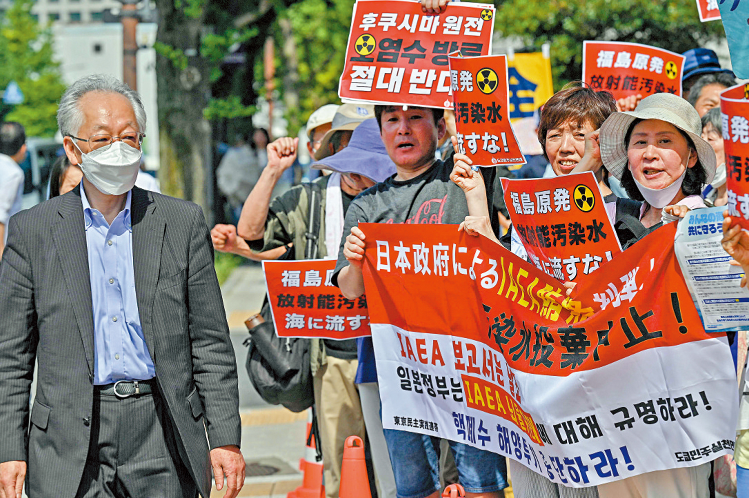 　　圖：日韓民眾12日在日本首相辦公室外舉牌示威，反對核污水排海計劃。\法新社