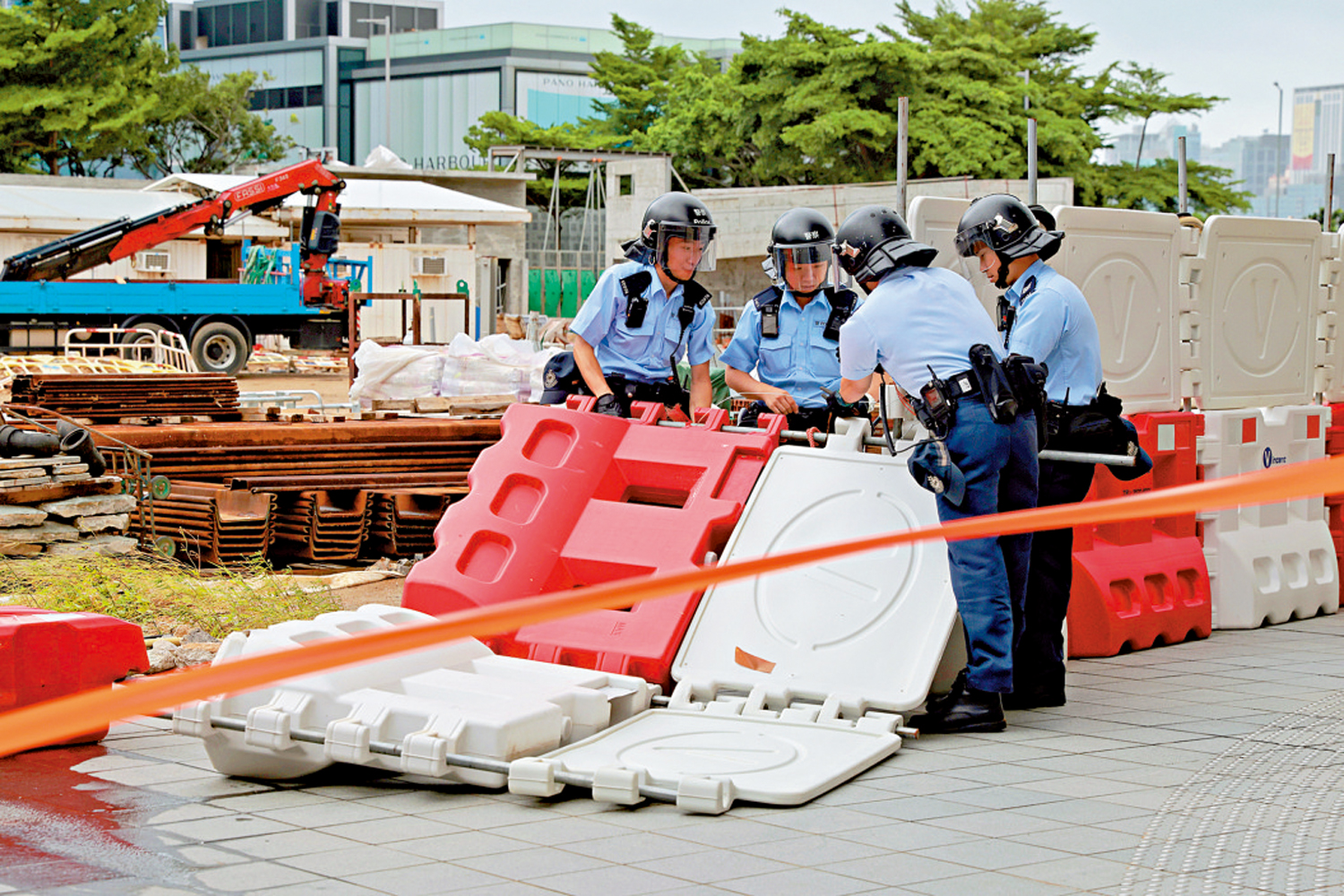 　　圖：打風期間，維港海旁一個工地有大片圍擋被強風吹倒，警員到場拉起警戒線並嘗試修復。\中通社