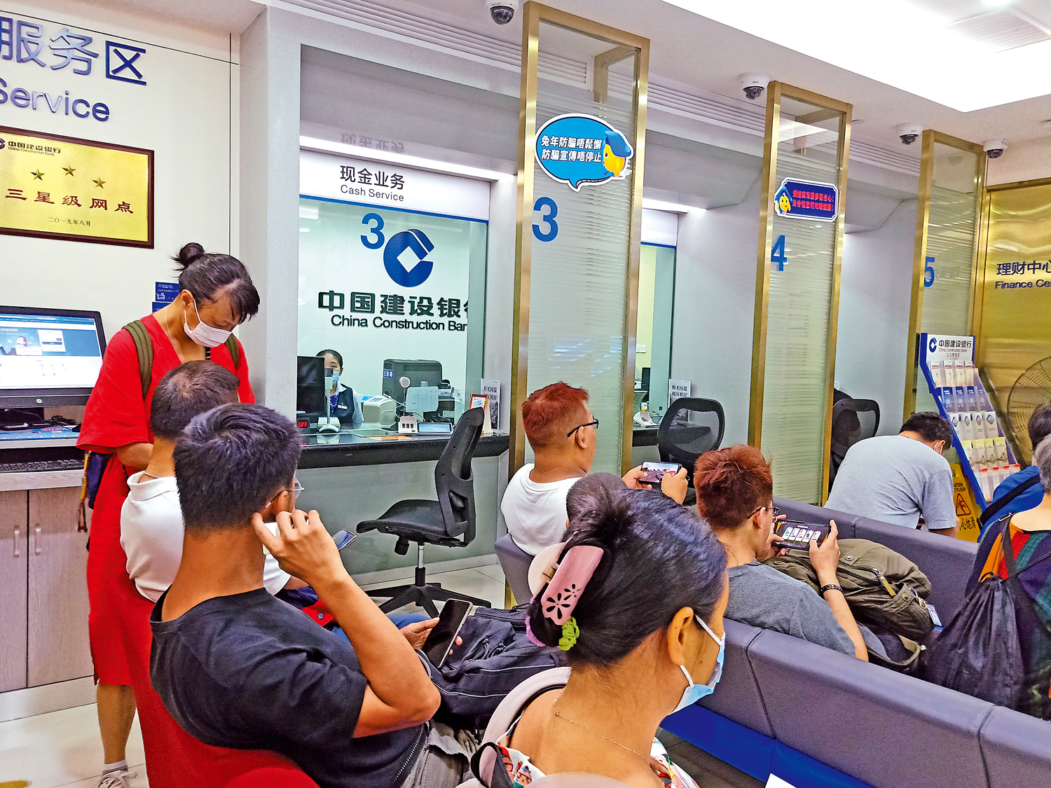 　　圖：20日，在中國建設銀行深圳分行羅湖商業城支行內，辦理業務的客戶耐心等待叫號。\大公報記者毛麗娟攝