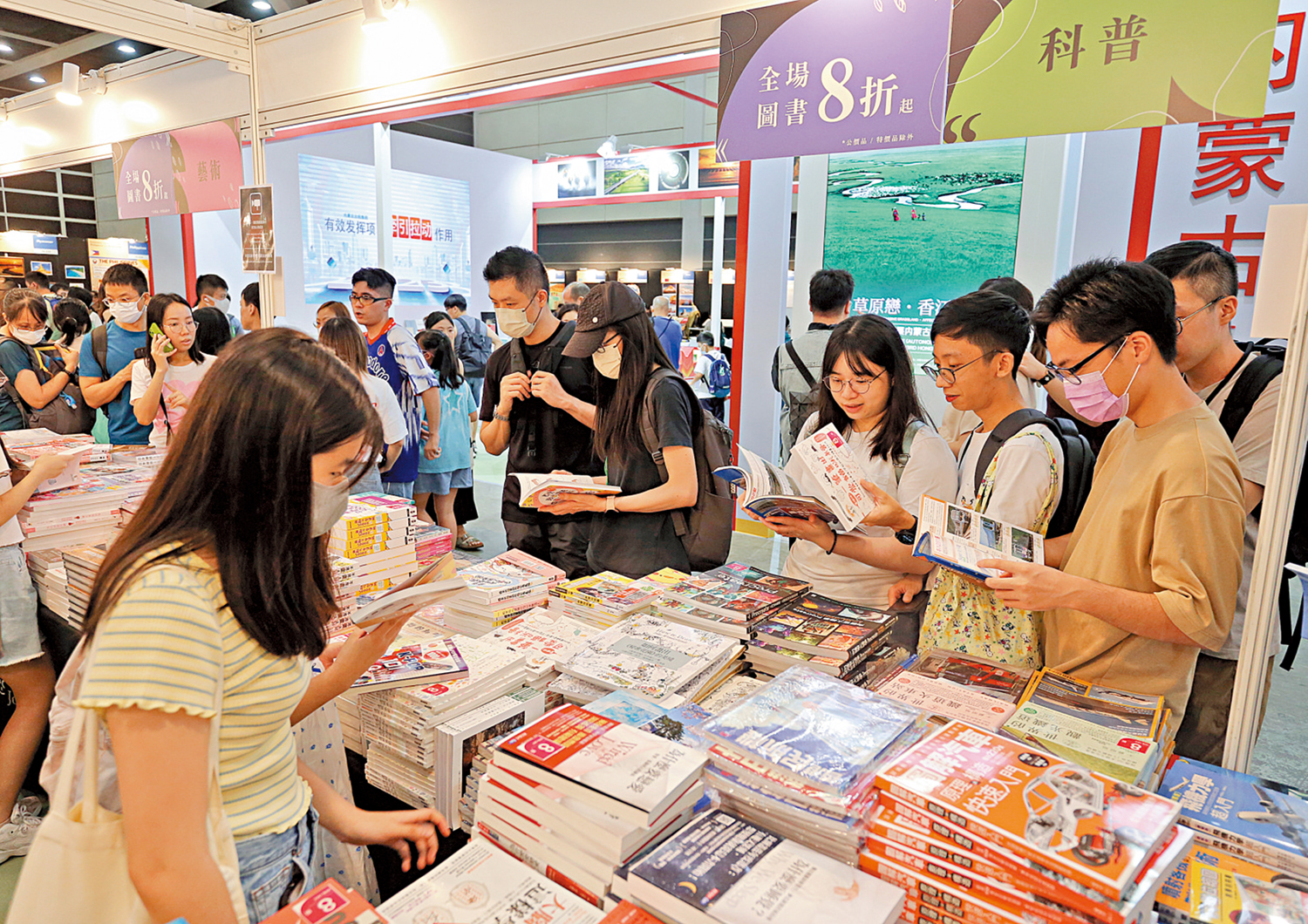 　　圖：眾人擠在攤位內挑選心水書籍。 大公報記者黃洋港攝