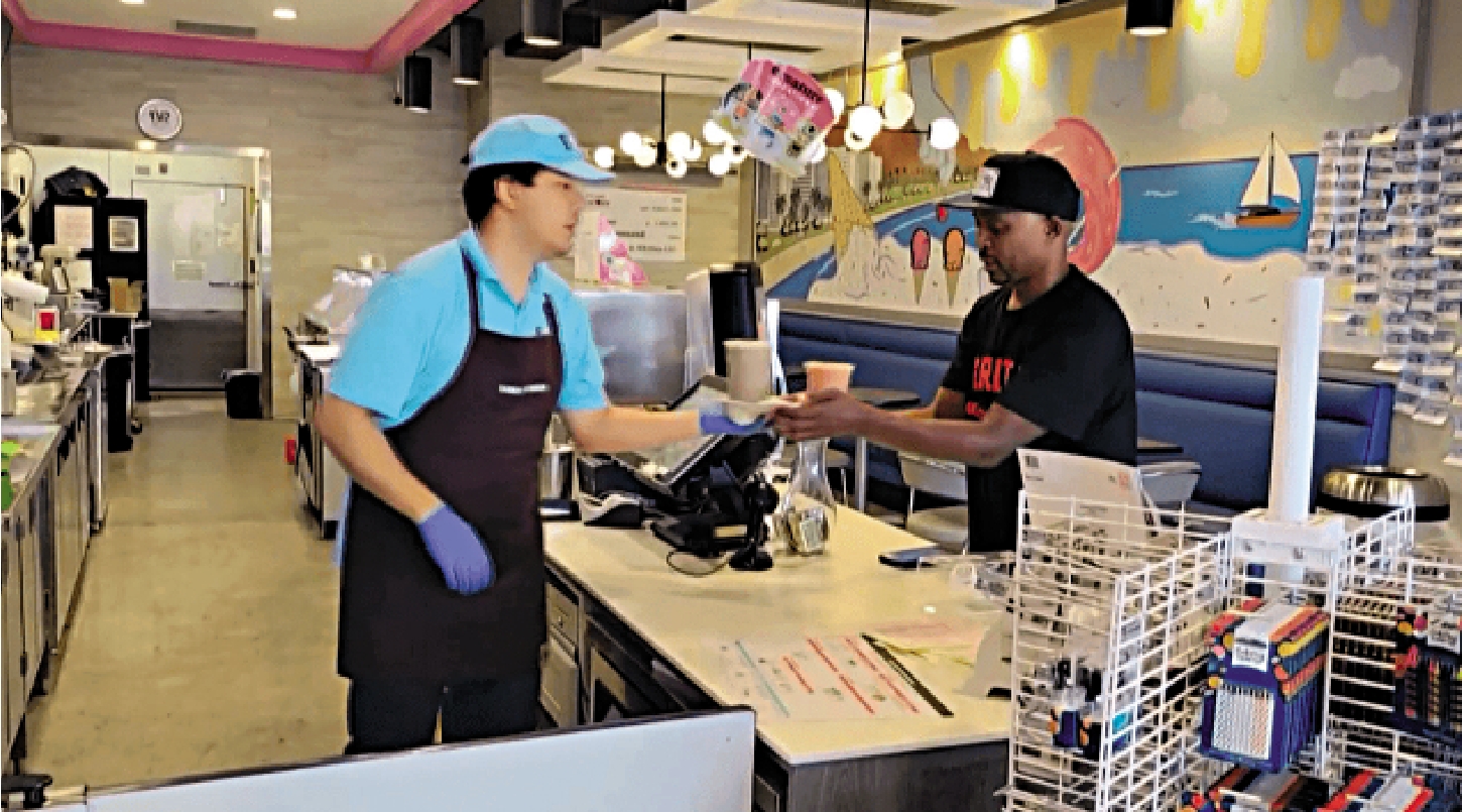 　　圖：科爾曼（右）在檀香山一家餐廳替顧客取餐。\網絡圖片