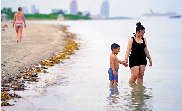 　　圖：7月28日，人們在佛羅里達州比斯坎灣的海灘戲水。/美聯社