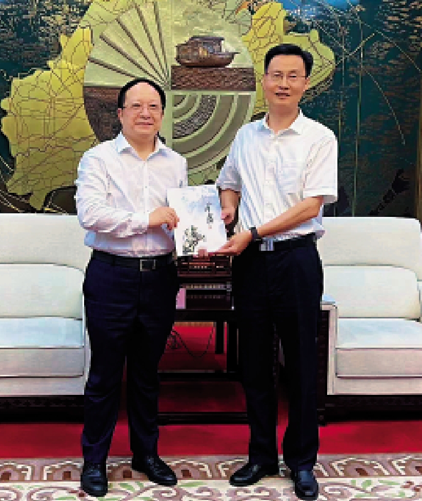 　　圖：李大宏（左）向陳偉（右）贈送金庸小說人物紀念郵票。/大公報記者王莉攝