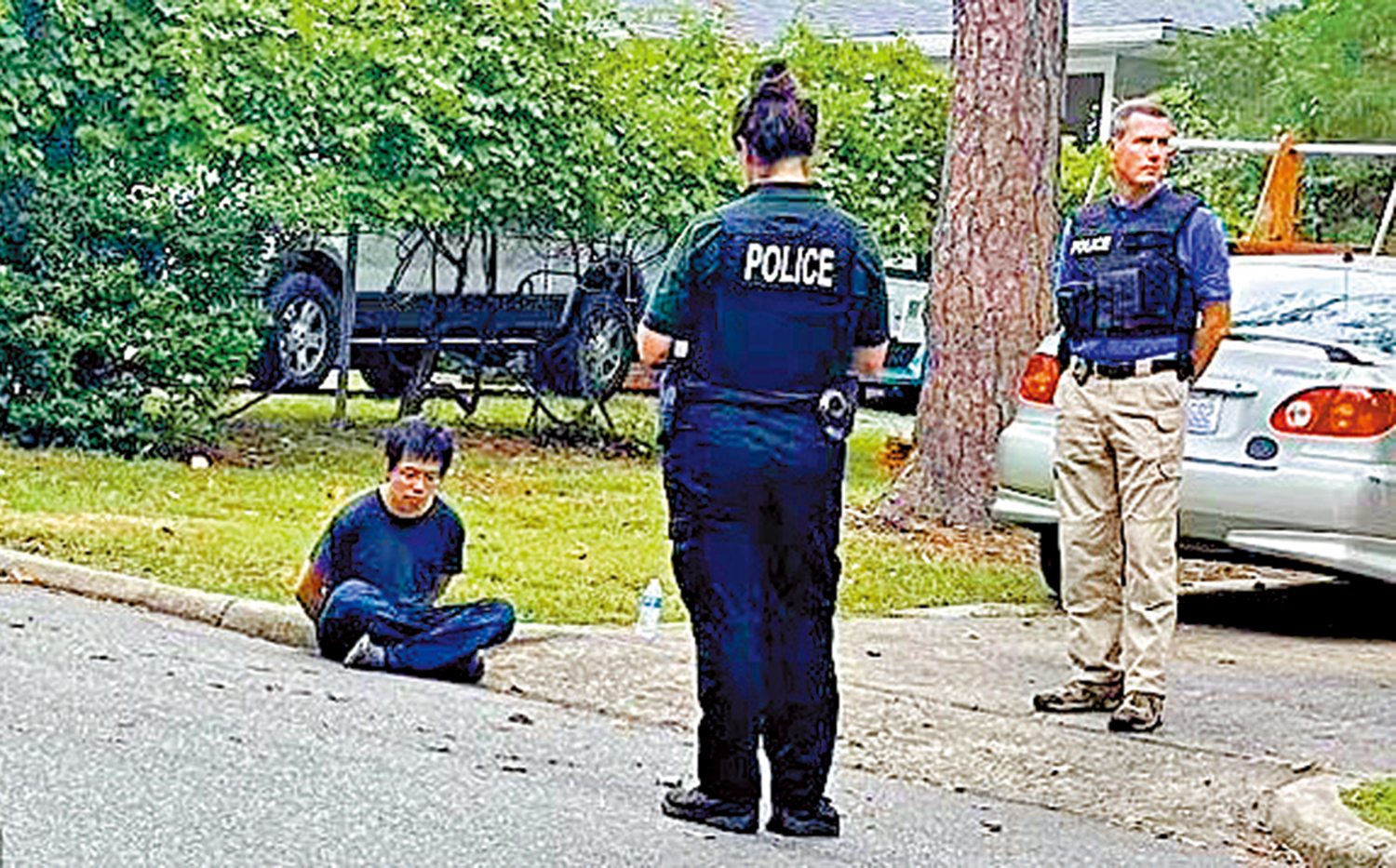 　　圖：嫌犯被戴上手銬，盤腿坐在馬路邊。\網絡圖片