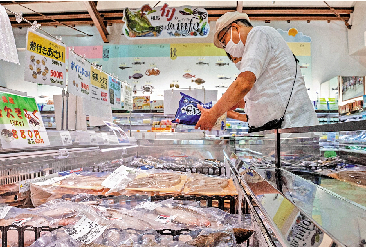 　　圖：中國頒布進口禁令，重創日本水產業。圖為顧客在福島縣魚市採購。/法新社