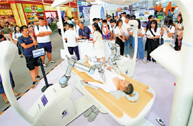 　　圖：9月5日，參觀者在服貿會觀看數字中醫循經治療機器人展示。\新華社