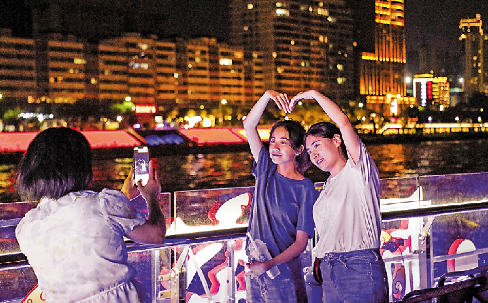 　　圖：7月26日，在黃河蘭州段，遊客欣賞兩岸夜景，在船上拍照留念。\新華社