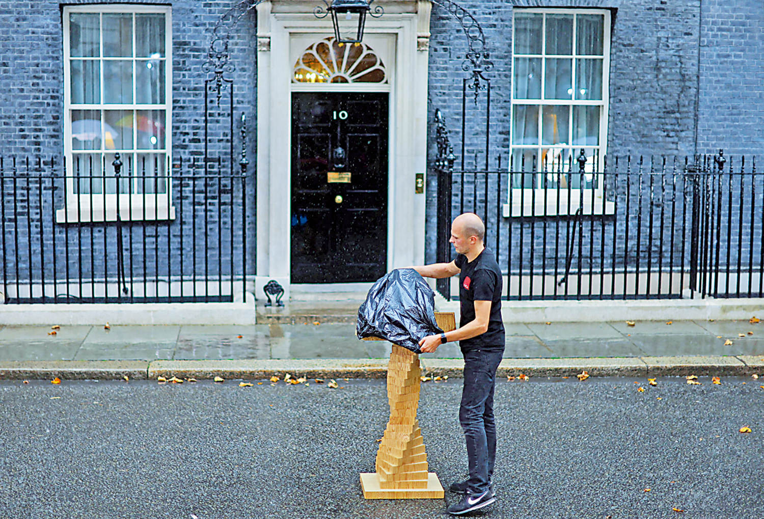 　　圖：去年九月六日，特拉斯正式出任英國首相，工作人員臨時用一個垃圾袋來保護擺放在首相府門前被雨淋的演講台。\路透社