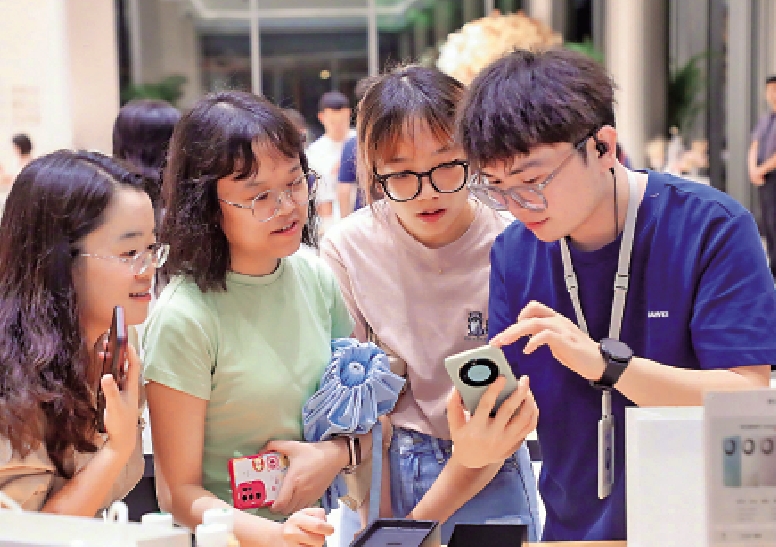 　　圖：在深圳一家華為旗艦店內，店員向顧客展示新機型的功能。