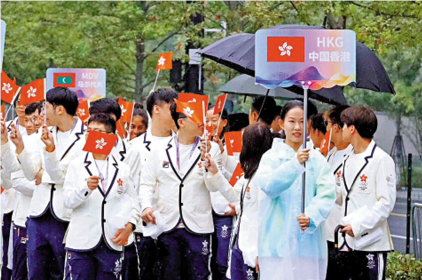 　　圖：中國香港體育代表團昨日在杭州亞運村舉行升旗典禮。圖為香港健兒冒雨進場觀禮。