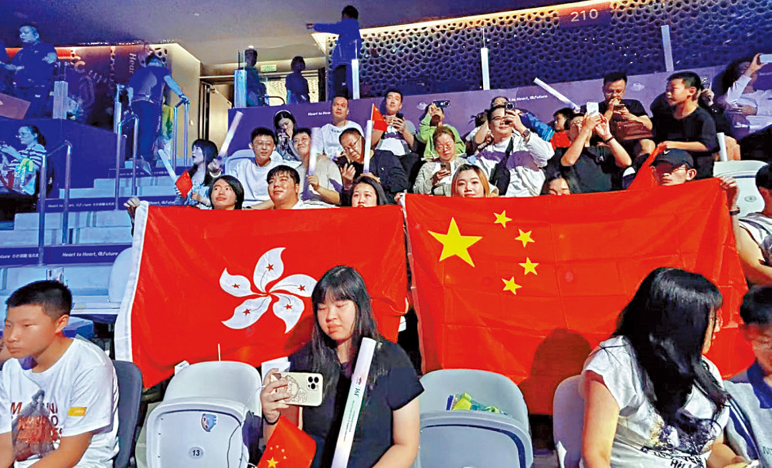 　　圖：現場觀眾分別舉起國旗和區旗為隊員助威。\大公報記敖敏輝攝