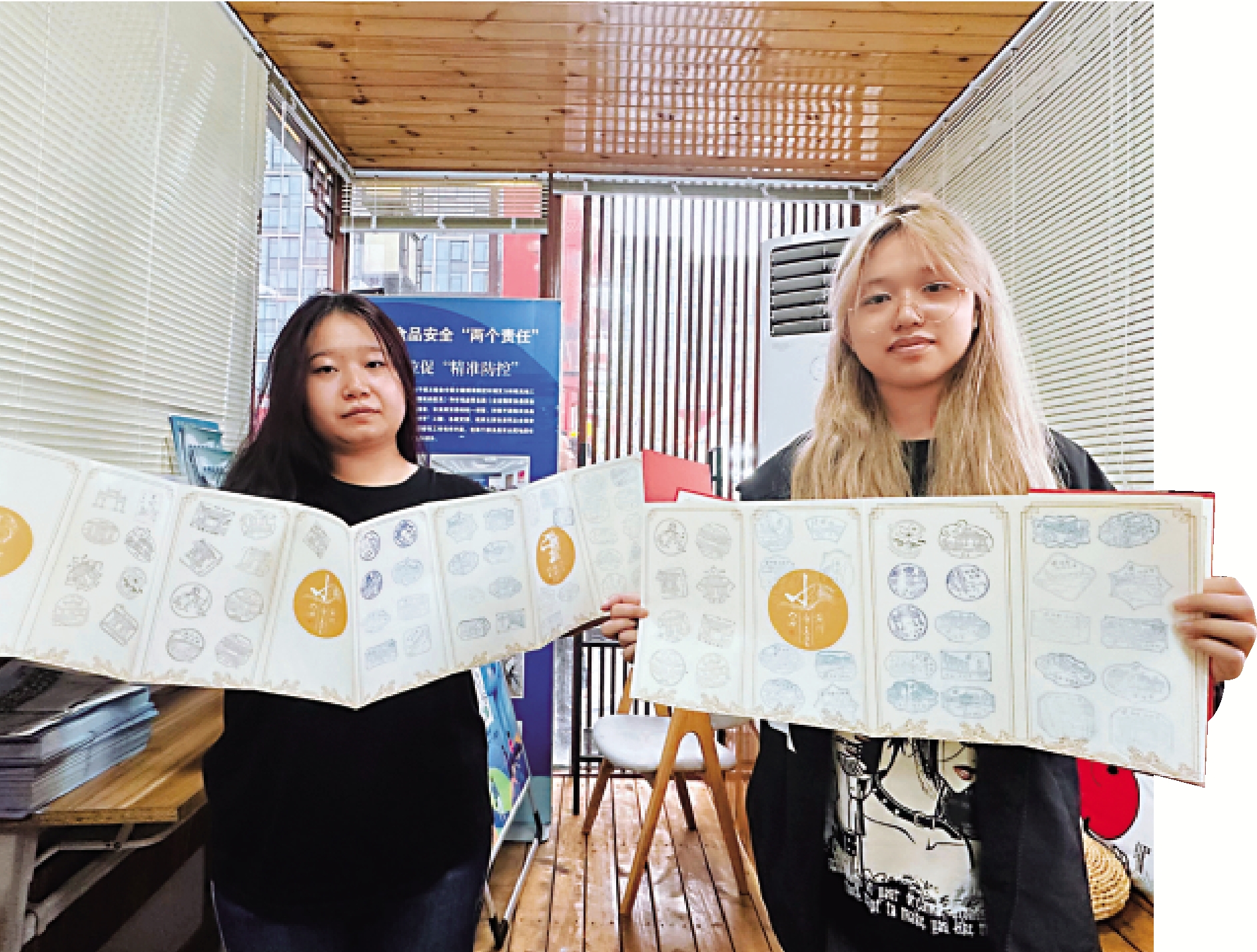 　　圖：濟南大學學生劉一諾（左）和同學展示她們收集到的濟南泉水印章。\大公報記者丁春麗攝