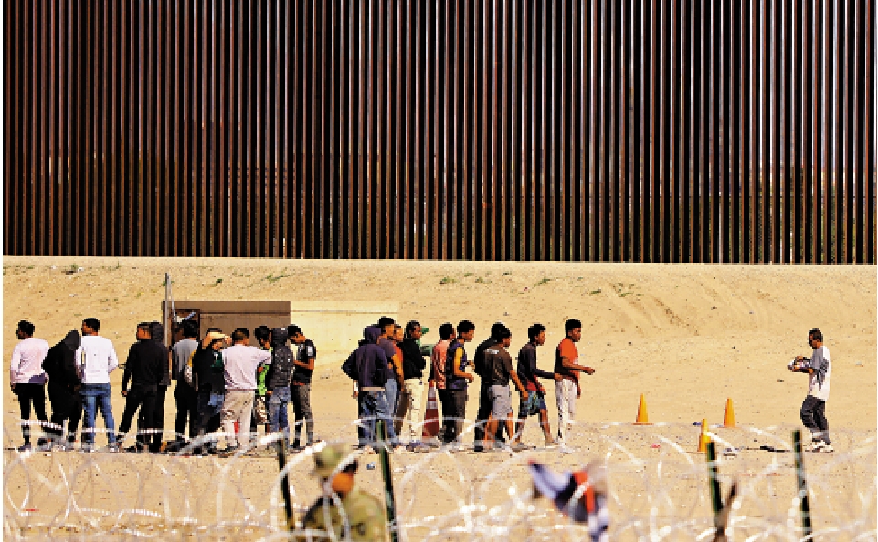 　　圖：美執法人員在美墨邊境攔截大批非法移民。\路透社