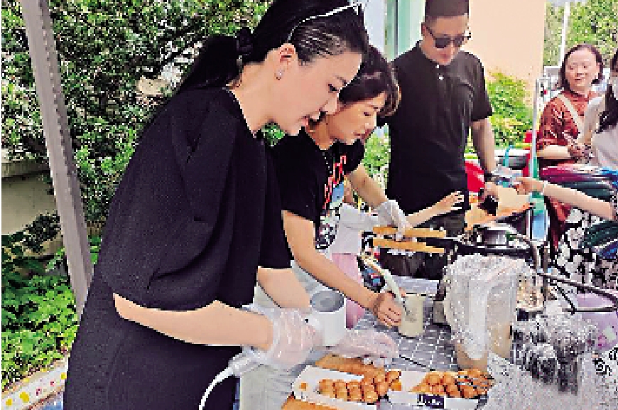 　　圖：六一兒童節，陳曉文（左一）在女兒的幼兒園裏製作台灣雞蛋仔。