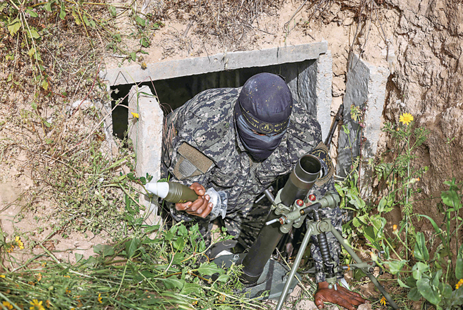 　　圖：2022年4月，一名巴勒斯坦傑哈德士兵在加沙一處隧道出口架設迫擊炮。\法新社