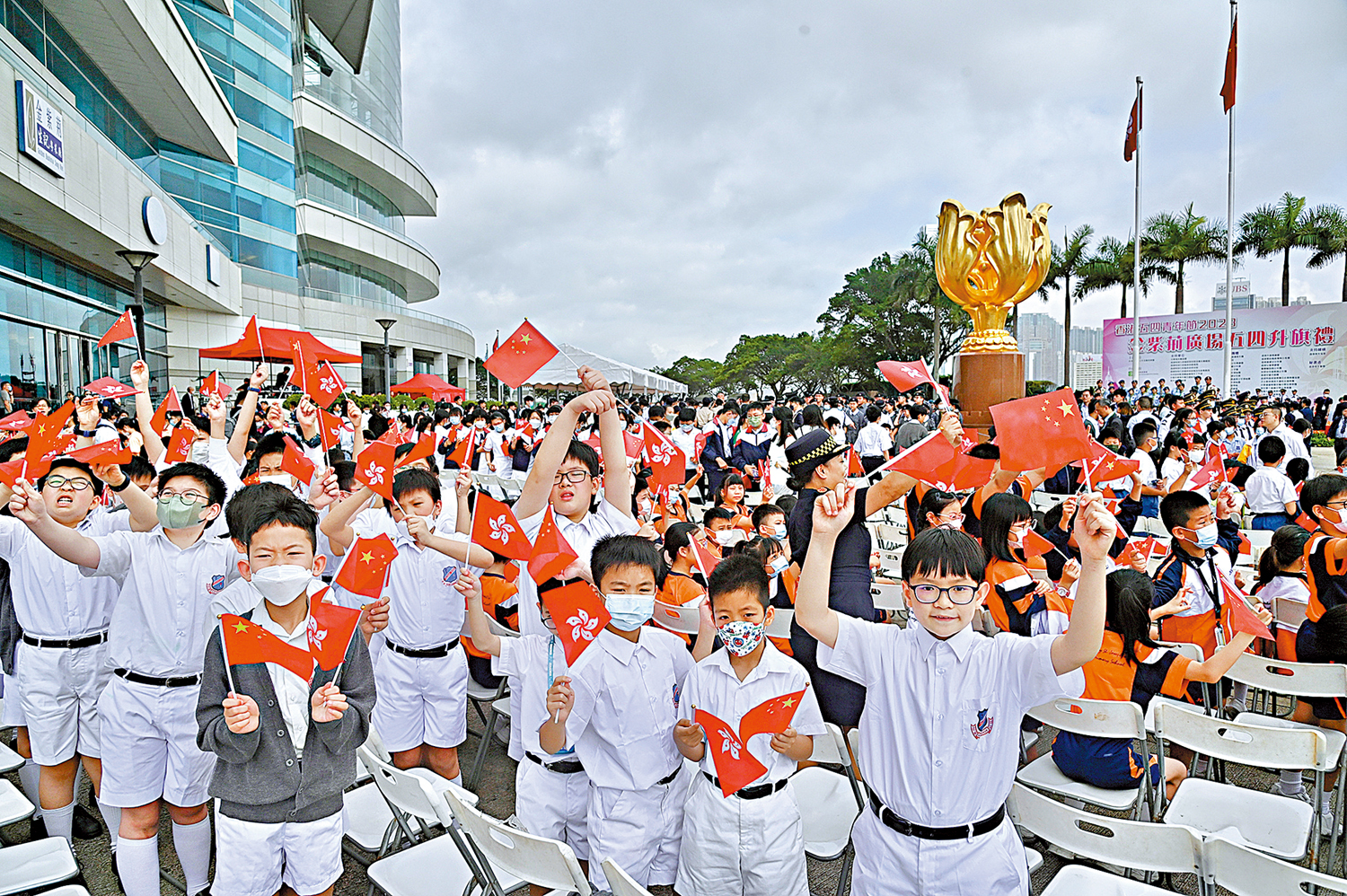 　　圖：今年5月4日早上，香港各界青少年活動委員會於疫情後首次復辦五四青年節升旗禮儀式，升旗禮於金紫荊廣場舉行。香港19個青少年制服團隊參與升旗禮，有大批中小學學生到場觀禮。儀式上，全體制服團隊以中式步操列隊進場，各代表朗讀「五四宣言」，活動凝聚香港青年的正能量，加強香港青年人對國家的認識及培養青年人對社會的承擔，展現青春與活力。圖為中小學學生參與五四升旗禮。\中新社