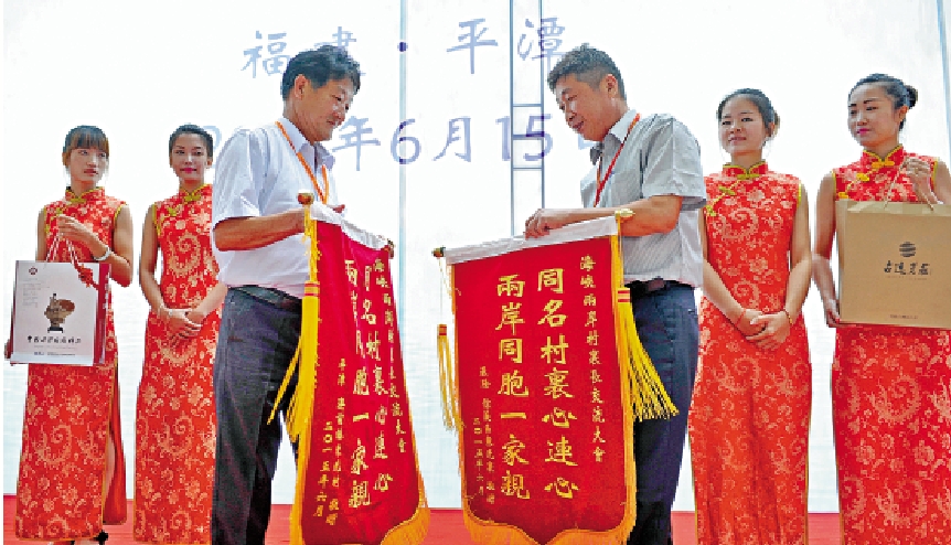 　　圖：台灣基隆市信義區東光里里長黃元良與福建平潭澳前鎮東光村村委會主任李滋成進行兩岸同名村錦旗交換和互贈禮品活動。\資料圖片