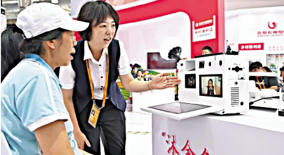 　　圖：在2023服貿會上，工作人員向參觀者介紹一款自主設計的視頻銀行。\新華社