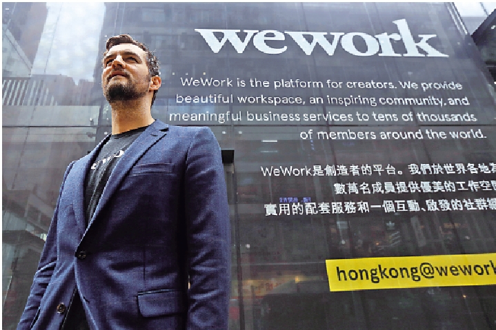 　　圖：2017年，WeWork聯合創始人麥凱爾維在香港WeWork旗艦店外。\路透社