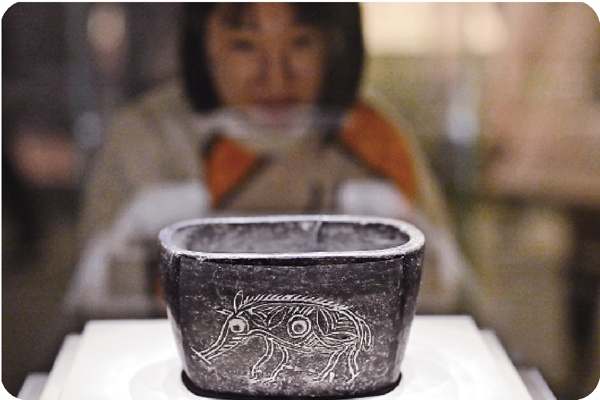 　　圖：展出的豬紋陶缽（新石器時代·河姆渡文化）。