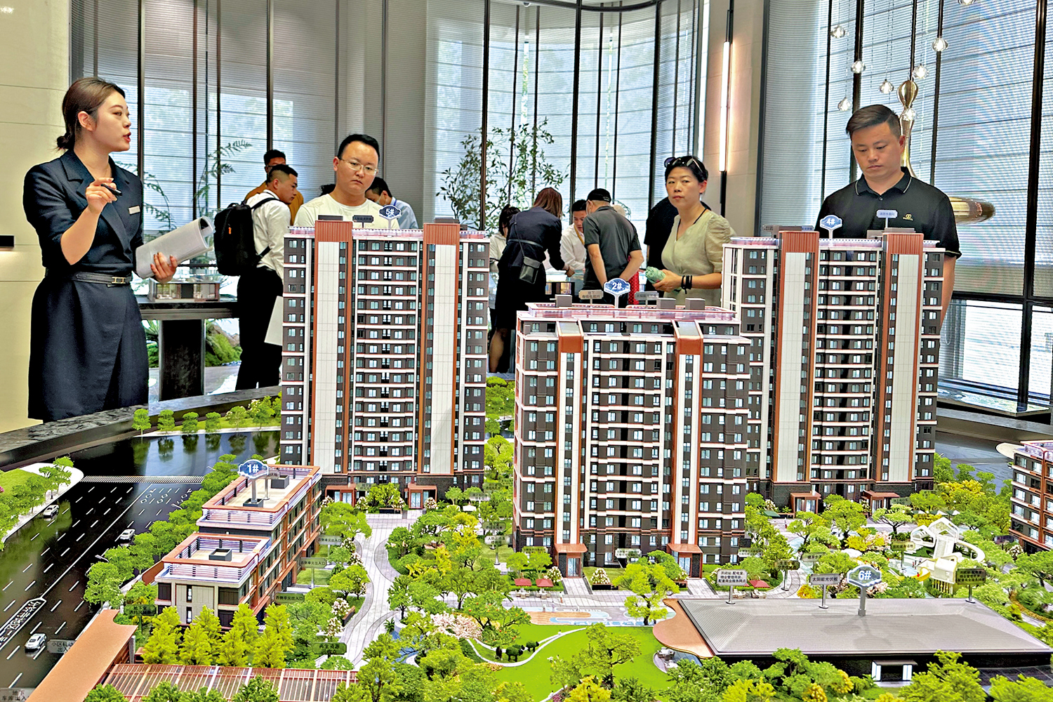 　　圖：中央經濟工作會議強調，要積極穩妥化解房地產風險。圖為民眾在北京一售樓處了解樓盤情況。\中新社