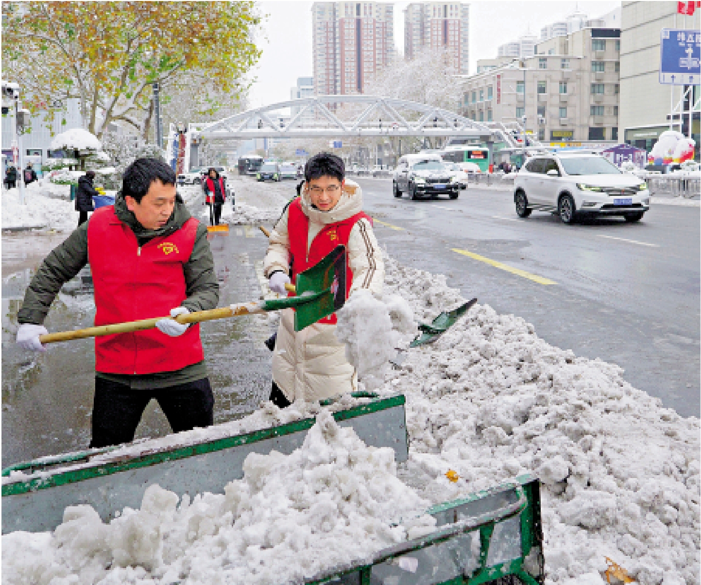 　　圖：12月11日，受強冷空氣影響，河南迎來今冬首輪大範圍雨雪天氣。在鄭州市花園路上，志願者清除道路積雪。/新華社