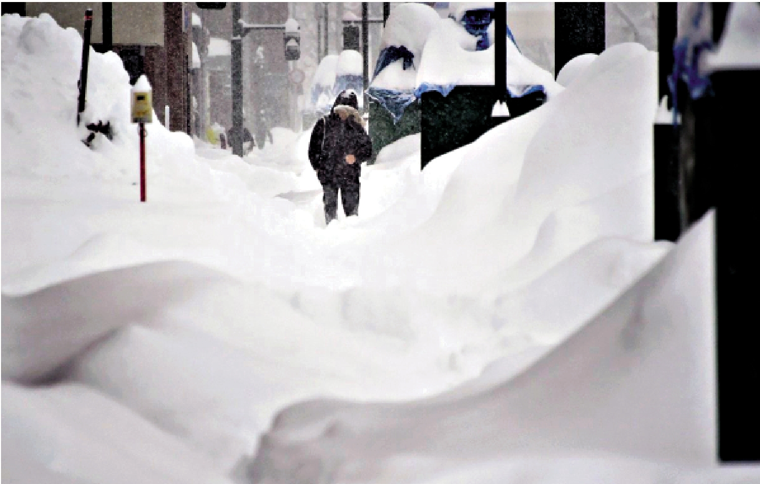 　　圖：日本北海道岩見澤市一民眾在雪中艱難行走。/網絡圖片