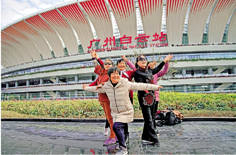 　　圖：開通首日，市民在廣州白雲站外拍照留念。