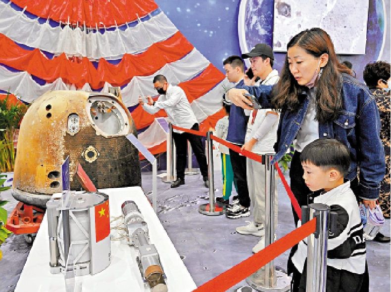 　　圖：2023年4月24日，觀眾在航天展科普展區參觀嫦娥五號返回器等實物。\新華社