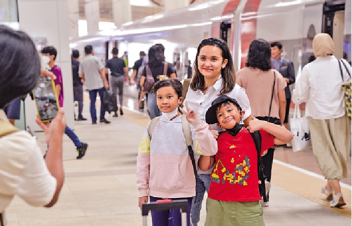 　　圖：印尼乘客在雅加達和雅萬高鐵車組合影。雅萬高鐵是中印尼合建的東南亞首條高鐵。\新華社