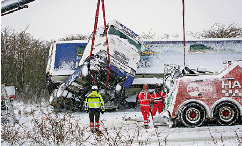 　　圖：救援人員3日在丹麥日德蘭半島的維堡，試圖打撈一輛在大雪中滑出路面的卡車。 美聯社