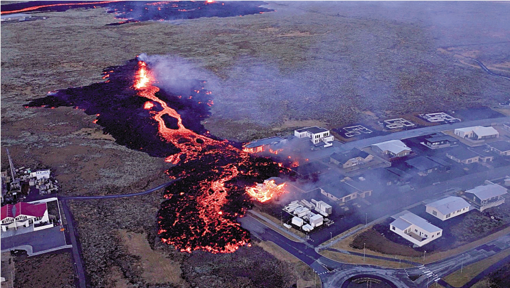 　　圖：熔岩14日從火山口噴出，湧入格林達維克鎮，點燃房屋。\路透社
